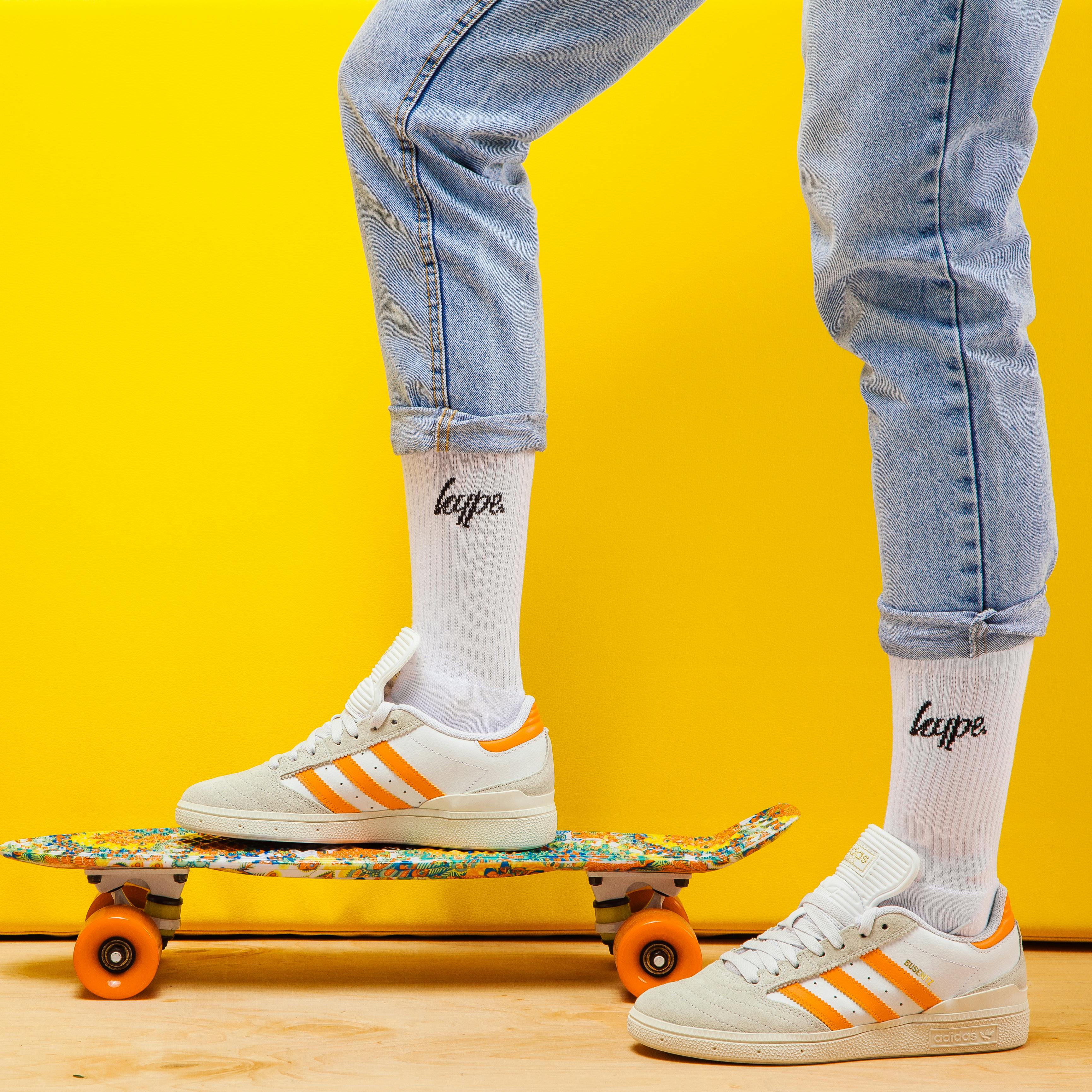 foot standing on a skateboard with custom sports socks