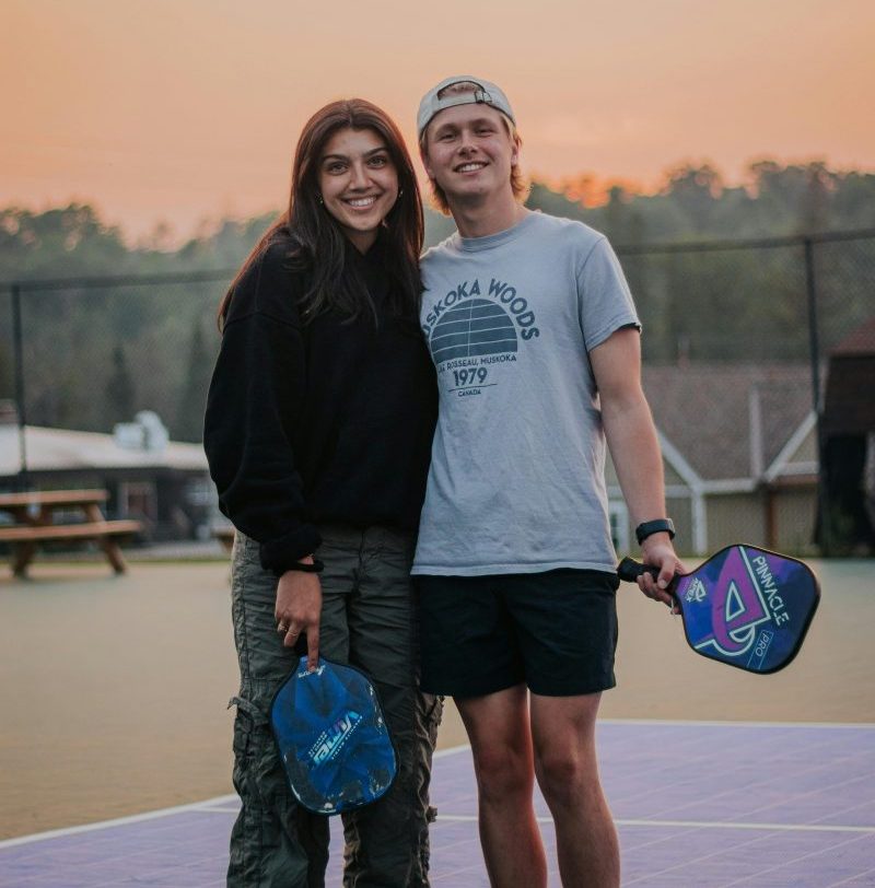 Young man and woman standing on a pickleball court