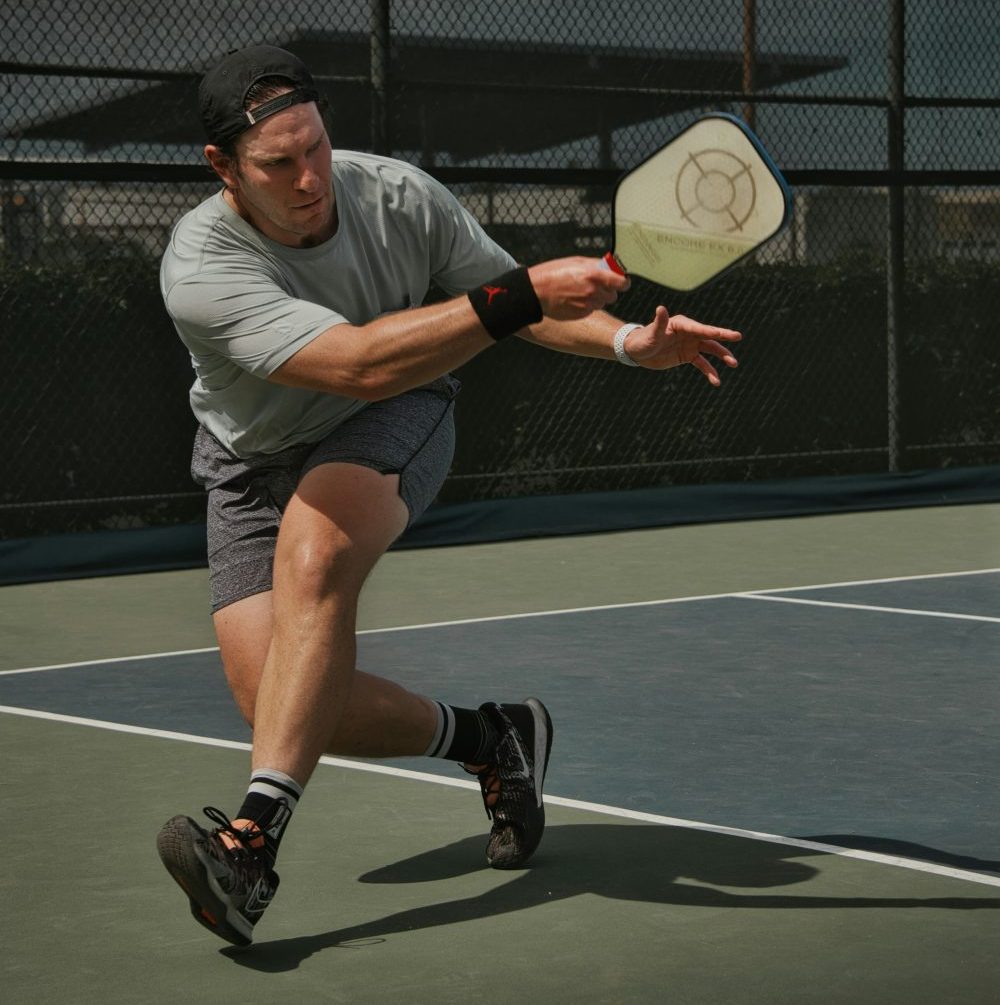 Man in gray crew neck t-shirt and gray shorts playing pickleball